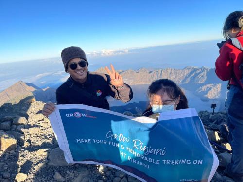 a man and a woman holding a sign at the top of a mountain at Rinjani in Bayan