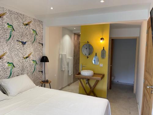 a bedroom with a bed and a wall with birds on it at Les Appart villa Sunbay Caraibes avec piscine privative vue mer et montagne in Le François