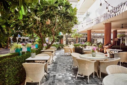 a restaurant with tables and chairs and trees at BYD Lofts - Boutique Hotel & Serviced Apartments - Patong Beach, Phuket in Patong Beach