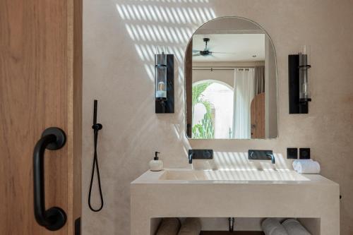 ein Bad mit einem Waschbecken und einem Spiegel in der Unterkunft Khaleela Villas in Canggu