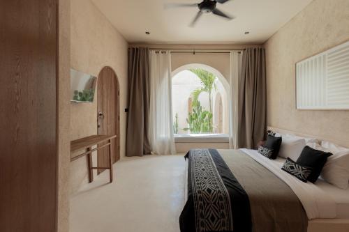 ein Hotelzimmer mit einem Bett und einem Fenster in der Unterkunft Khaleela Villas in Canggu
