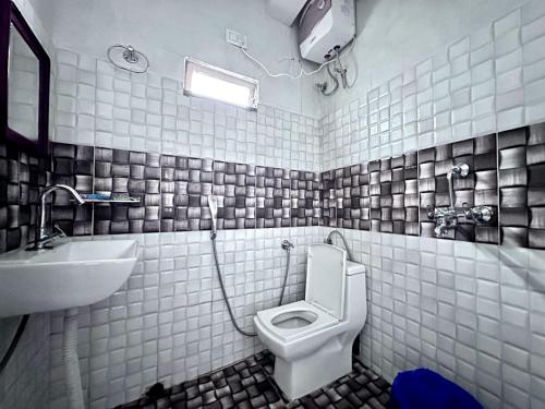 a bathroom with a toilet and a sink at Syengden Nikunj in Darjeeling