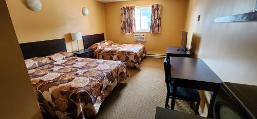 a hotel room with two beds and a desk at VIKING INN in Gimli