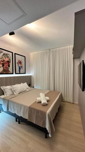 1 dormitorio con 1 cama y TV en Blend Marista, en Goiânia