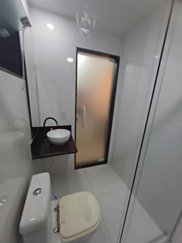 a bathroom with a toilet and a sink and a mirror at Loft em Olaria in Rio de Janeiro