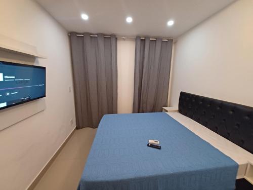 a room with a bed with a remote control on it at Loft em Olaria in Rio de Janeiro