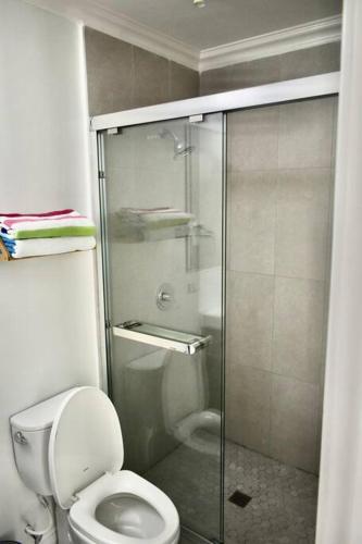 a bathroom with a toilet and a glass shower at Irie Vibes Ocean View in Negril