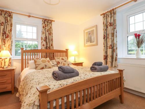 a bedroom with a bed with two towels on it at Coombe Cottage in Borrowdale