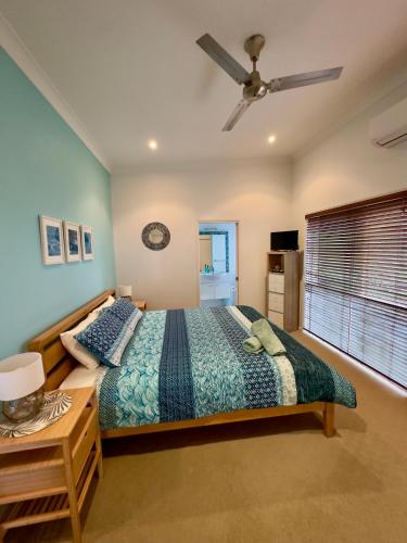 a bedroom with a bed and a ceiling fan at Blue Ocean View Beach House, Tangalooma Resort in Tangalooma