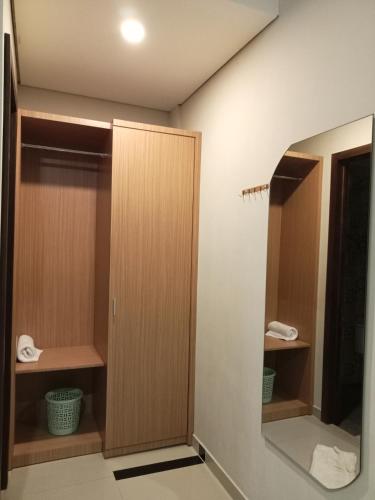 a bathroom with wooden cabinets and a mirror at Beringin view hotel & Resort in Batealit