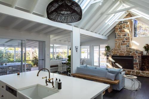 a kitchen and living room with a stone fireplace at Soul of Gerringong Farmhouse in Gerringong