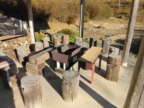 a group of wooden benches and wooden logs at BANRYU 萬龍 バンリュウ in Iida