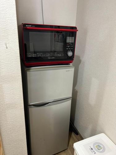 a microwave sitting on top of a refrigerator at Comfy Stay TDS in Nara