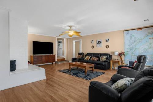 a living room with a couch and a tv at Elegant Huge Ocean View 4 King, Private Pool, Huge Yard, Enormous Game Garage, BBQ, & Rooftop Deck in Myrtle Beach