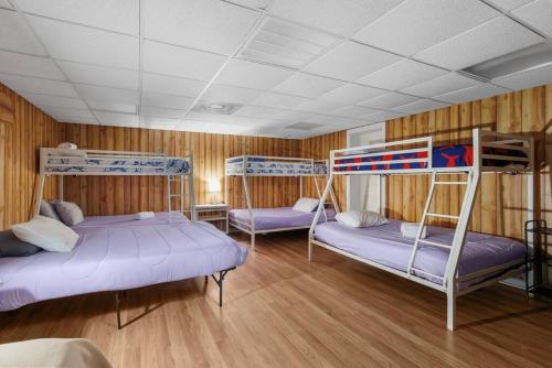 two bunk beds in a room with wooden walls at Elegant Huge Ocean View 4 King, Private Pool, Huge Yard, Enormous Game Garage, BBQ, & Rooftop Deck in Myrtle Beach