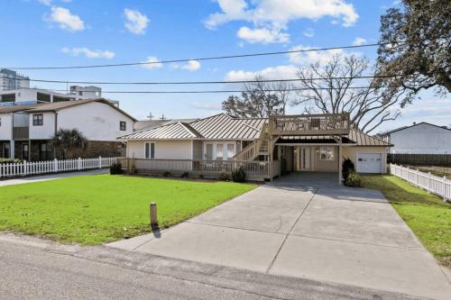a house with a porch and a yard at Elegant Huge Ocean View 4 King, Private Pool, Huge Yard, Enormous Game Garage, BBQ, & Rooftop Deck in Myrtle Beach