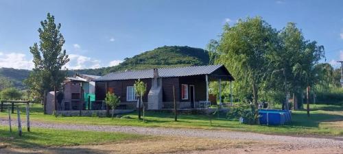 una pequeña casa con una colina en el fondo en CABAÑA LA DELFINA en Yerba Buena