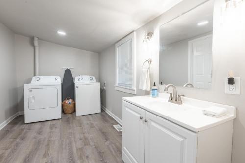 a white bathroom with a sink and a washer and dryer at Kansas City Riverside Retreat in Kansas City