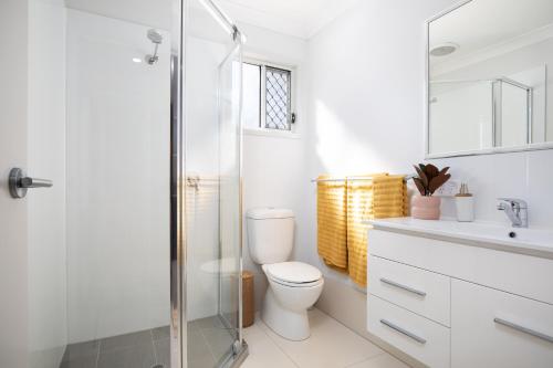 a bathroom with a toilet and a glass shower at Neatly Presented,Air Con and Modern! in Brisbane