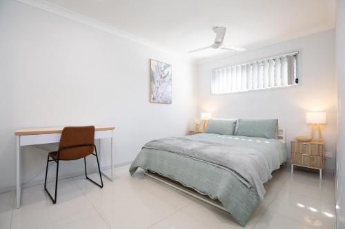 a bedroom with a bed and a desk and a chair at Neatly Presented,Air Con and Modern! in Brisbane