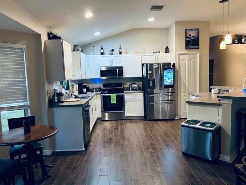 a kitchen with stainless steel appliances and a wooden floor at Ruskin FL 2 bdrm 1 bath suite Host & Cat share common areas in Ruskin