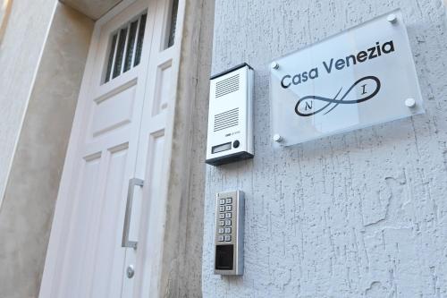 a sign on the side of a building next to a door at casa Venezia in Carovigno
