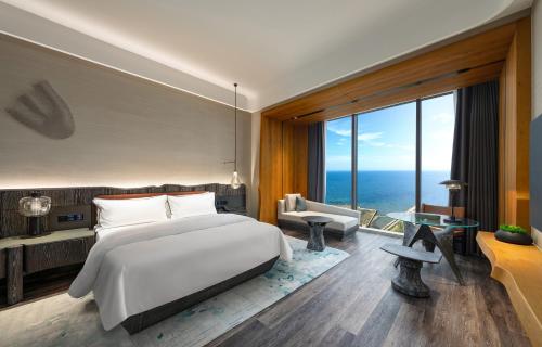 a bedroom with a large bed and a large window at The Westin Yantai in Yantai
