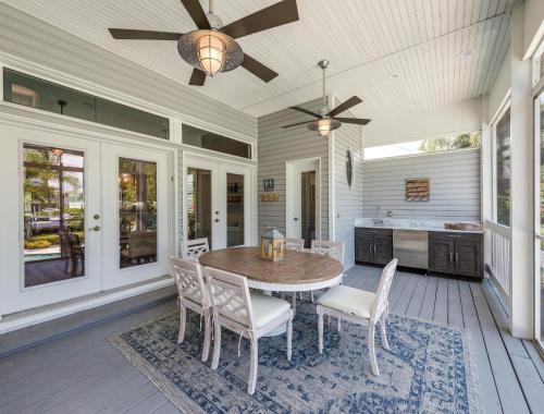 a dining room with a table and chairs on a porch at Isla Amor - 86 in Siesta Key