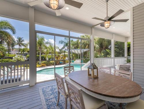 a screened porch with a table and chairs and a pool at Isla Amor - 86 in Siesta Key