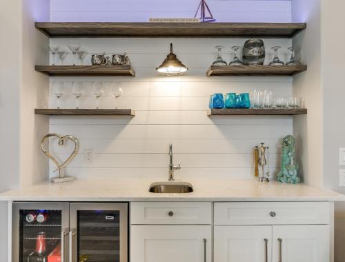 a kitchen with a sink and shelves with glasses at Isla Amor - 86 in Siesta Key