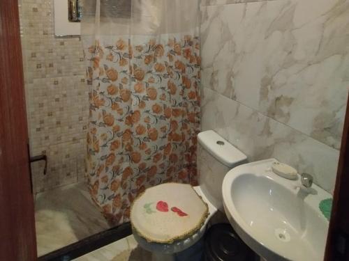 a bathroom with a toilet and a sink at Casa amarela 1 quarto in Cabo Frio