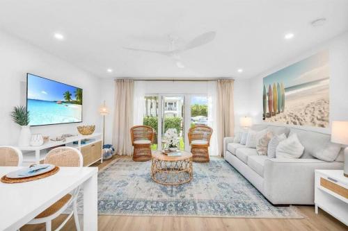 a living room with a couch and a table at Luxury Beachside Condo 1 Steps to the Beach in Juno Beach