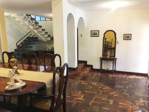 a dining room with a table and a staircase at Mi Casa en Rio in Riobamba