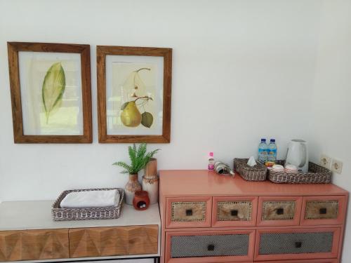una cómoda roja con dos cuadros en la pared en Le Kekeri Villas Collection en Mataram