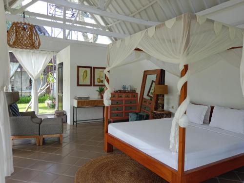 - une chambre avec un lit à baldaquin dans l'établissement Le Kekeri Villas Collection, à Mataram