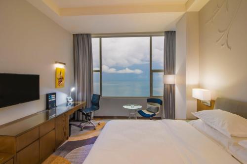 a hotel room with a bed and a large window at Four Points by Sheraton Manado in Manado