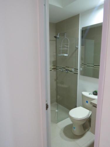 a bathroom with a toilet and a glass shower at Espléndido y Fantástico Apartamento en Girardot. 4 Piscinas, WiFi, Parque infantil, Parqueadero privado. in Girardot