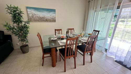 uma sala de jantar com uma mesa de vidro e cadeiras em Charmant appartement a 1km de la plage, avec piscine a Albufeira em Albufeira