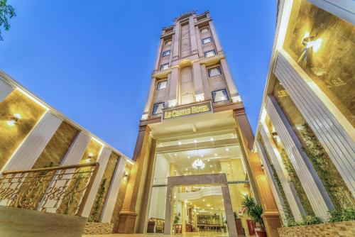 a building with a clock tower in the middle at Le Centre Pleiku Hotel in Pleiku