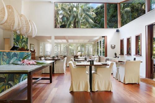 a restaurant with tables and chairs and large windows at Arajilla Retreat in Lord Howe