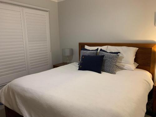 - une chambre avec un grand lit blanc et des oreillers bleus dans l'établissement 21 On Court, à Mudgee