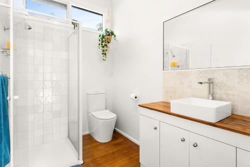 a white bathroom with a toilet and a sink at Seabreeze at silverleaves in Rhyll