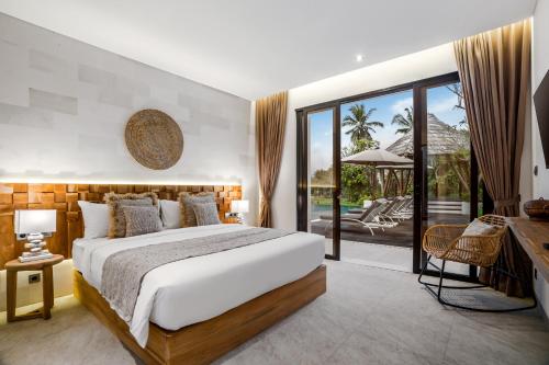a bedroom with a large bed and a balcony at Villa Pearl by BaliSuperHost in Ubud