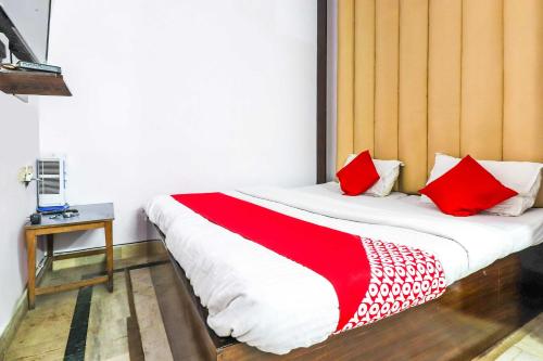- une chambre avec un lit doté d'oreillers rouges et blancs dans l'établissement Flagship Hotel Prem Chunaria, à Moradabad