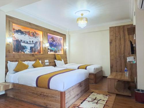 a bedroom with two beds and a chandelier at Prem Durbar Hotel & Nagarkot Zipline in Nagarkot