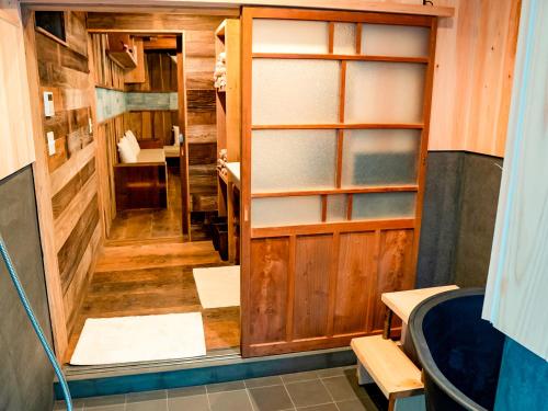 Pokój z drewnianymi drzwiami i umywalką w obiekcie GOYADO w mieście Ozu