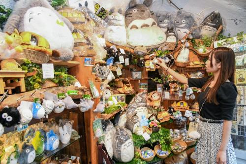 a woman standing in front of a display of stuffed animals at ＹＵＦＵＩＮ　ＦＬＯＲＡＬ　ＶＩＬＬＡＧＥ　ＨＯＴＥＬ in Yufu