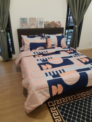 1 dormitorio con cama con edredón y almohadas en Gallery@U12Homestay, en Shah Alam