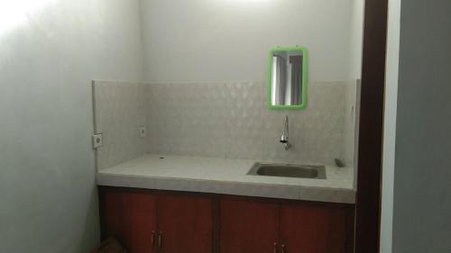 a bathroom with a sink and a mirror at Risal Guest House in Munggu
