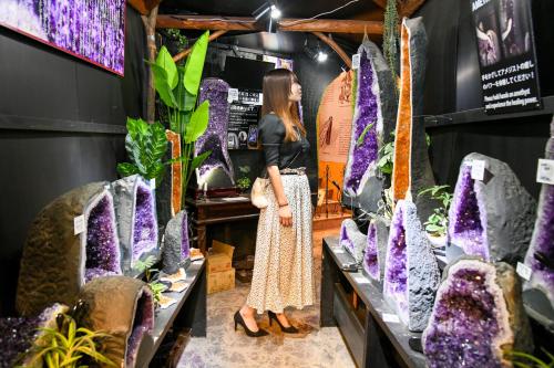 a woman standing in front of a display of flowers at ＹＵＦＵＩＮ　ＦＬＯＲＡＬ　ＶＩＬＬＡＧＥ　ＨＯＴＥＬ in Yufu